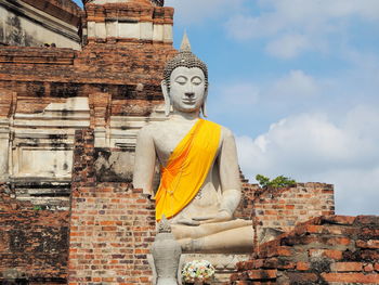 Statue against temple building against sky