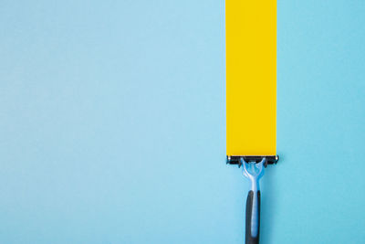 Close-up of yellow metal against blue background