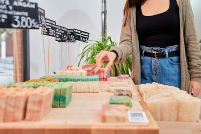 Midsection of woman standing at market stall