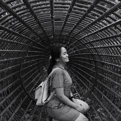 Smiling woman kneeling in metallic structure