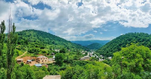 Scenic view of townscape and trees against sky