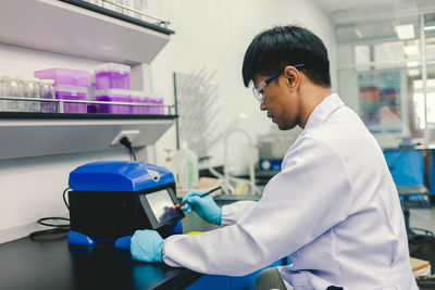 Side view of young man working in laboratory