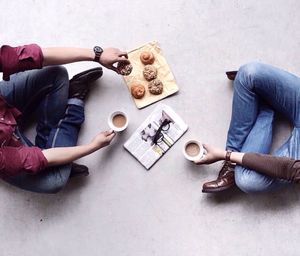 Low section of friends having breakfast on floor