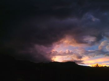 Silhouette of mountain against cloudy sky