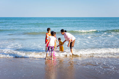 People enjoying on beach against sky
