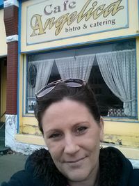 Portrait of young woman standing in front of building