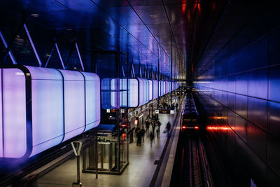 Train at illuminated railroad station at night