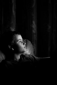 Cute boy looking away in darkroom