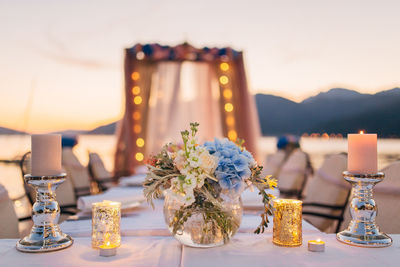 Close-up of illuminated tea light on table at restaurant