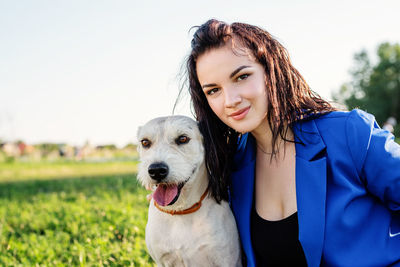 Portrait of woman with dog against sky