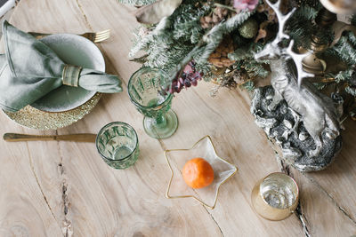 Christmas flat lay background. cutlery with wine glasses, tangerine, fir or spruce branches