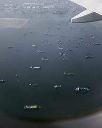 High angle view of airplane flying over sea in city