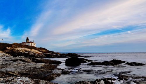 Seashore against cloudy sky