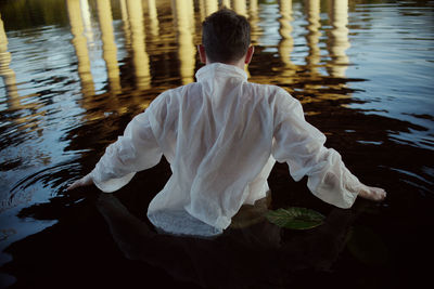 Rear view of man standing in lake