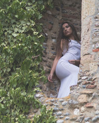 Low angle view of beautiful woman against wall