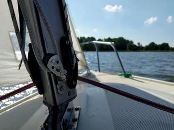 Close-up of boat sailing on sea against sky