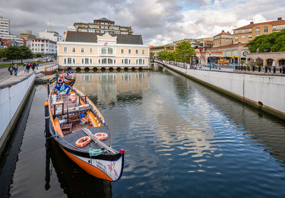 Boats in canal amidst buildings in city