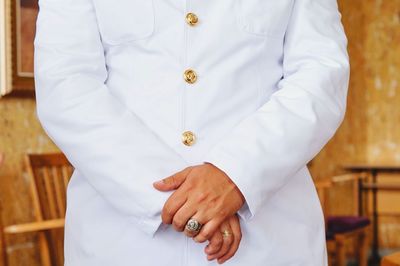 Midsection of man wearing white uniform