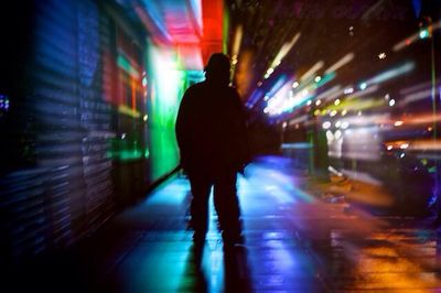 Blurred motion of woman in city at night