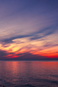 Scenic view of sea against dramatic sky during sunset