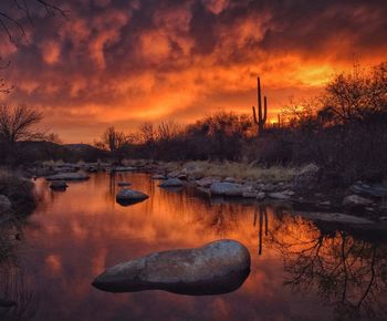 Scenic view of lake against orange sky