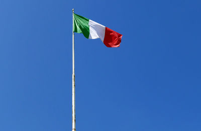 Bright and sunny italian flag waving against the blue sky