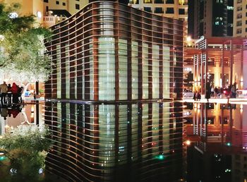 Full length of woman looking at illuminated city skyline at night