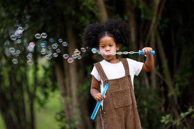 Full length of girl holding bubbles