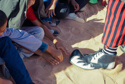 Low section of people standing on sand