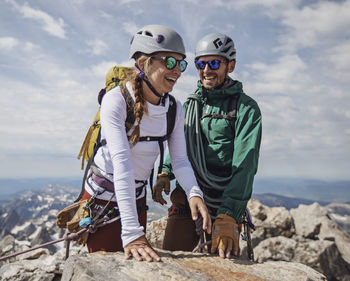 Couple smiles with joy after reaching summit of grand teton, wyoming