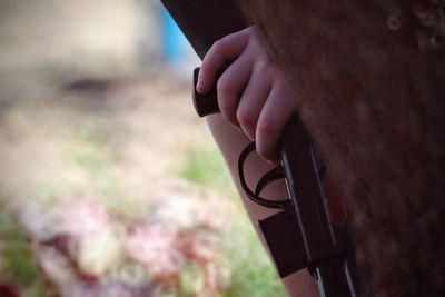 Cropped image of child holding toy gun