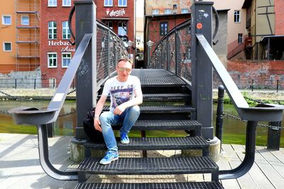 Full length of man sitting on staircase