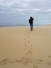 Rear view of man walking on beach