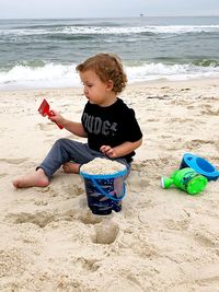 Boy playing with shovel on beach