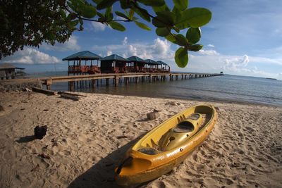 Scenic view of beach against cloudy sky