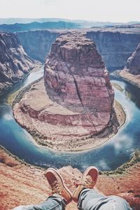 Low section of man sitting against horseshoe bend