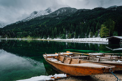 Boat moored by lake against mountains