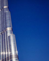 Low angle view of buildings against clear blue sky