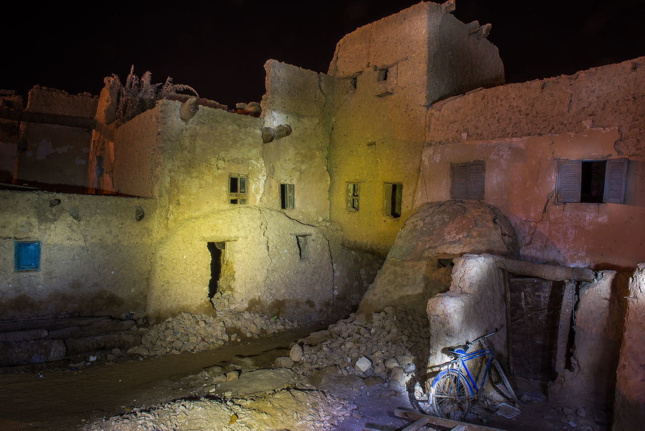 OLD BUILDING BY ILLUMINATED WALL