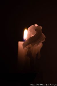 Close-up of illuminated candle against black background