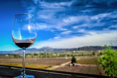 Close-up of wineglass against sky