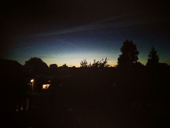 Silhouette of trees against sky at dusk