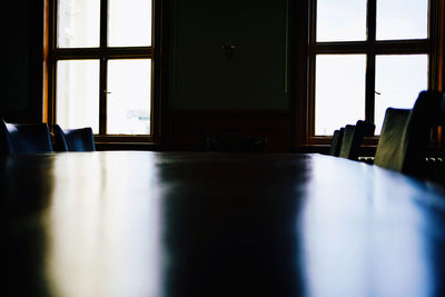 Empty chairs and table by window