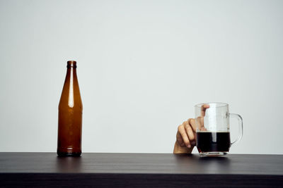 Close-up of wine glass on table against white background