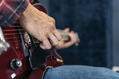 Midsection of man playing guitar