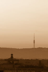 Silhouette of communications tower in city