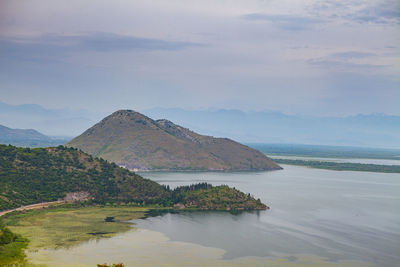 Scenic view of sea and mountains against sky