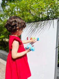 Side view of girl playing with toy on whiteboard.  she played a montessori for her second birthday 