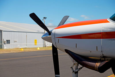 Airplane on airport runway against sky