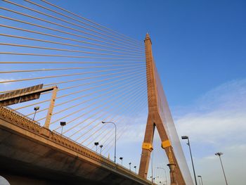 Low angle view of bridge and buildings against blue sky